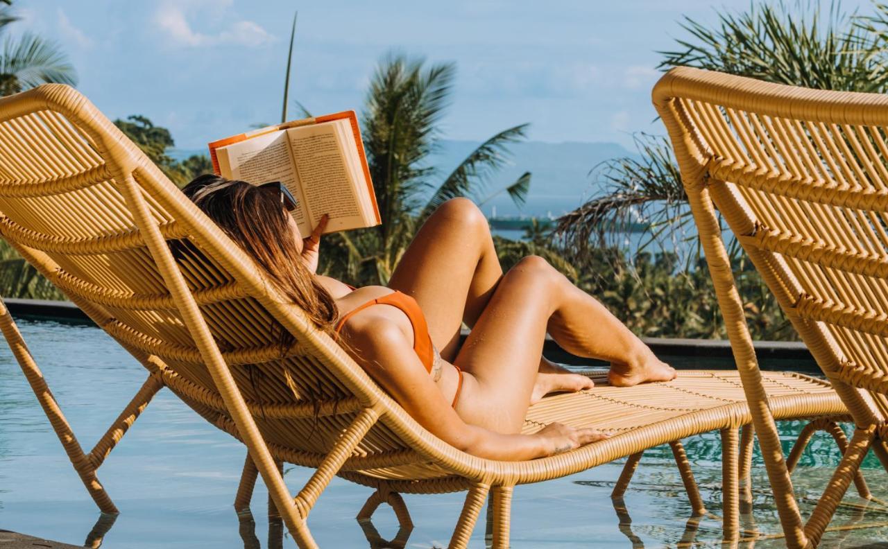 Neano Escape Hotel Manggis Екстериор снимка A woman reading a book on a beach